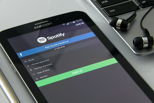 A smartphone displays the Spotify app on its screen.